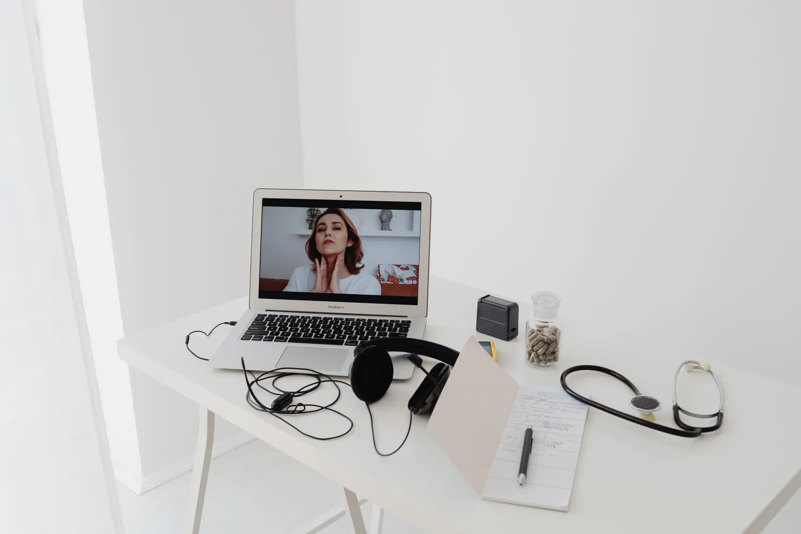 Laptop and headphones arranged for a virtual healthcare consultation